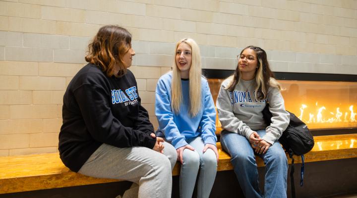 Student talking next to the fireplace