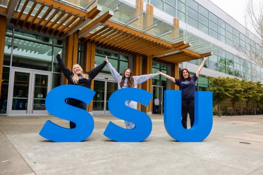 Students celebrating next to the SSU letters